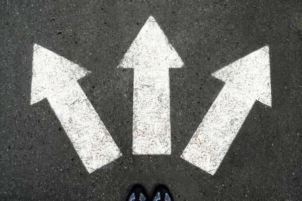 three-white-arrows-pointing-in-different-directions-on-gray-asphalt_72482-333